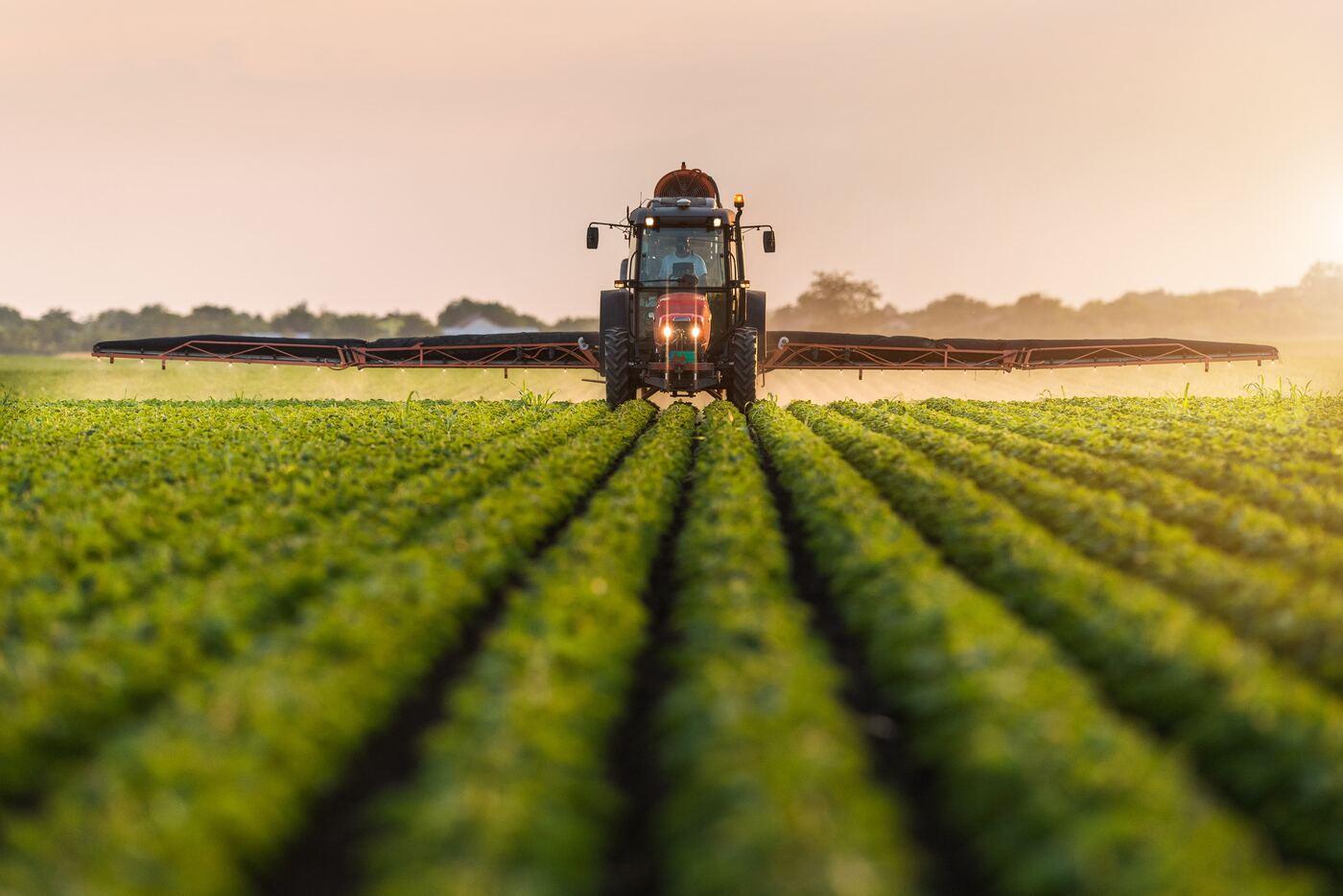 Tractor aplicando aspersión en un campo de cultivo